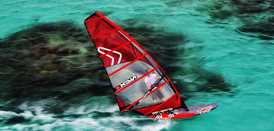 Windsurfing board used by sailor with high tech windsurfing sails